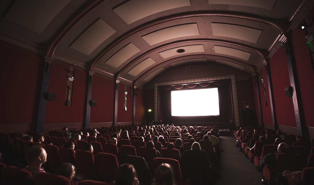 group of people staring at monitor inside room cinema d’esssai