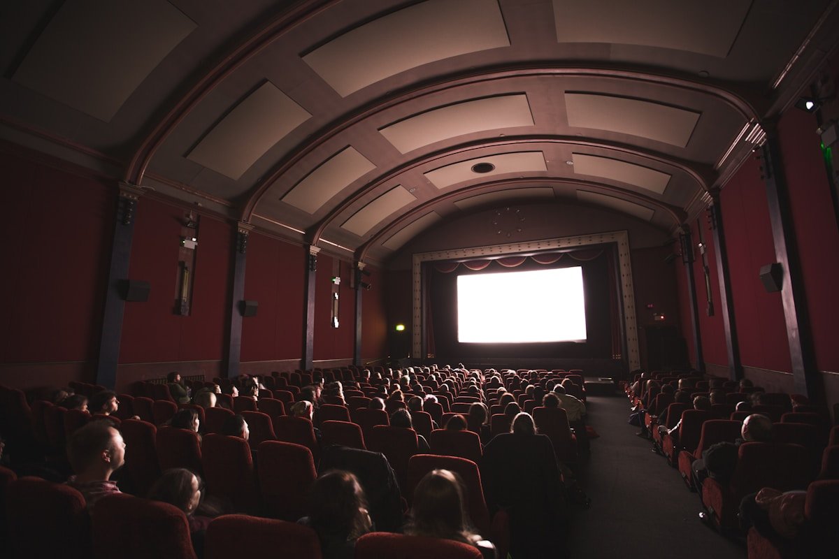 group of people staring at monitor inside room cinema d’esssai