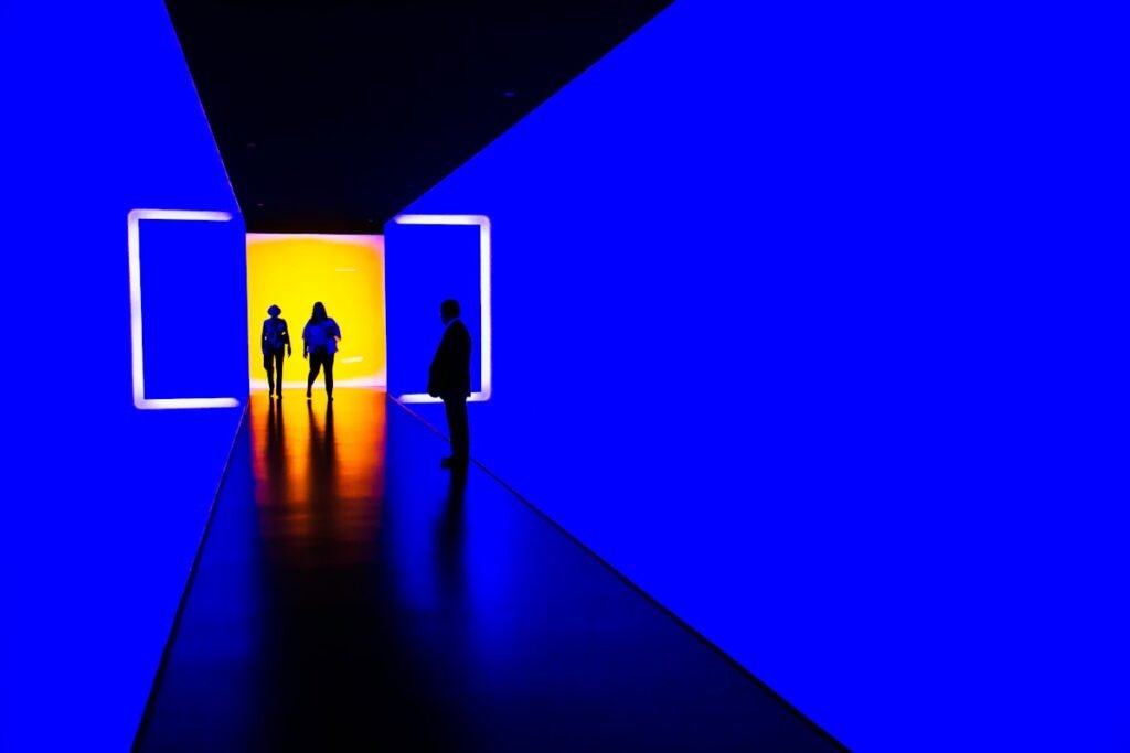 three person standing near wall inside building futuro del cinema a Milano