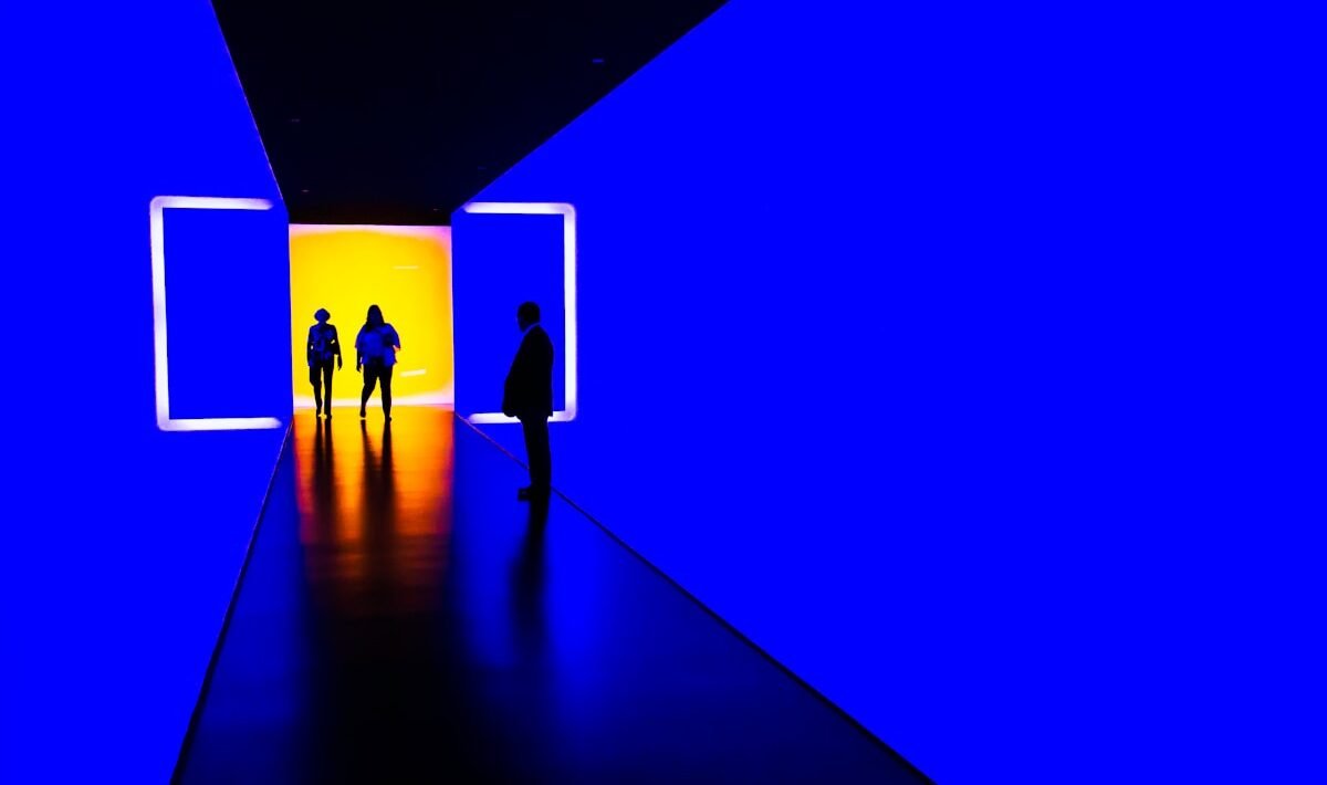 three person standing near wall inside building futuro del cinema a Milano